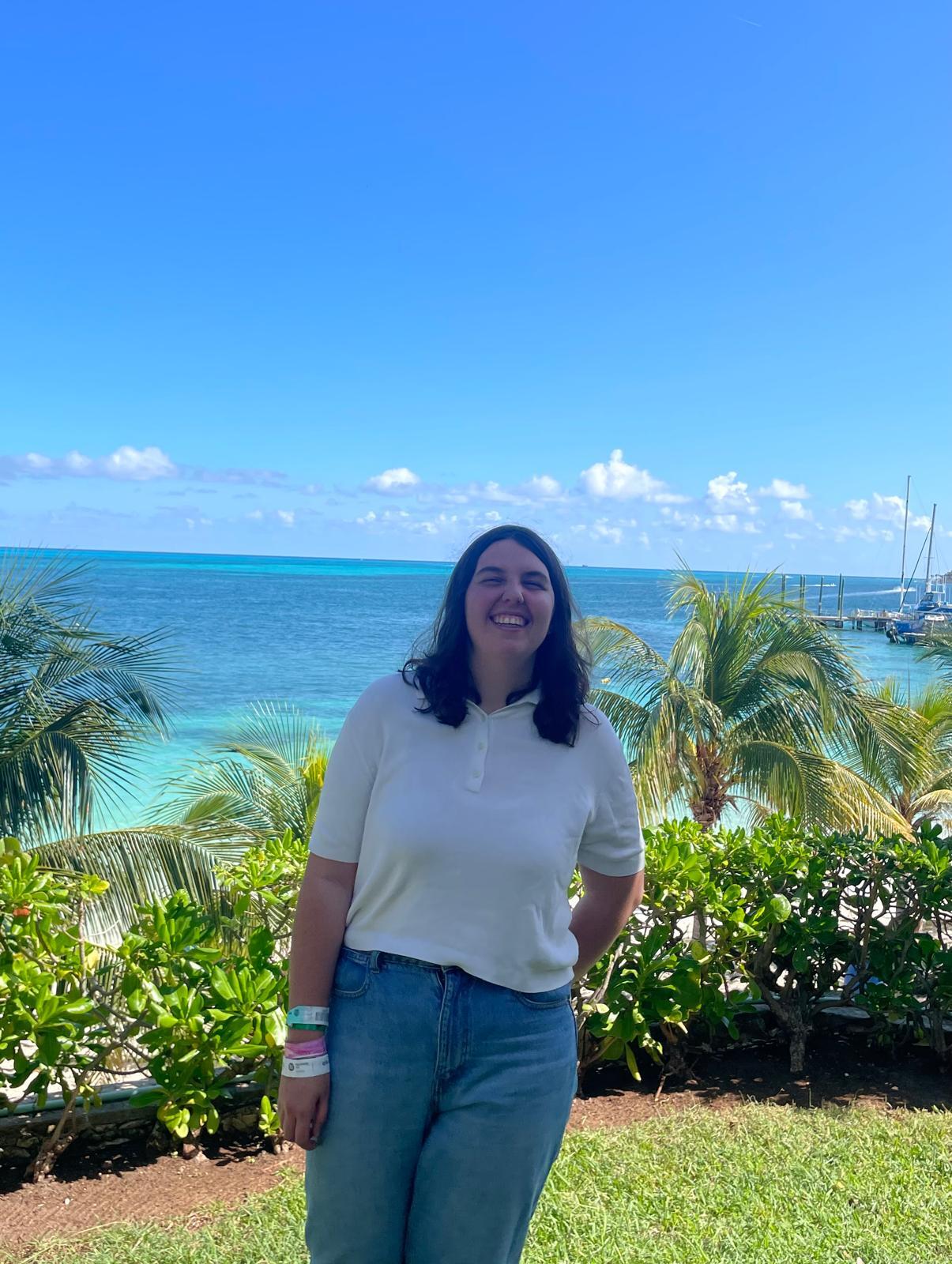 A picture of Laia standing in front of the sea, smilint.